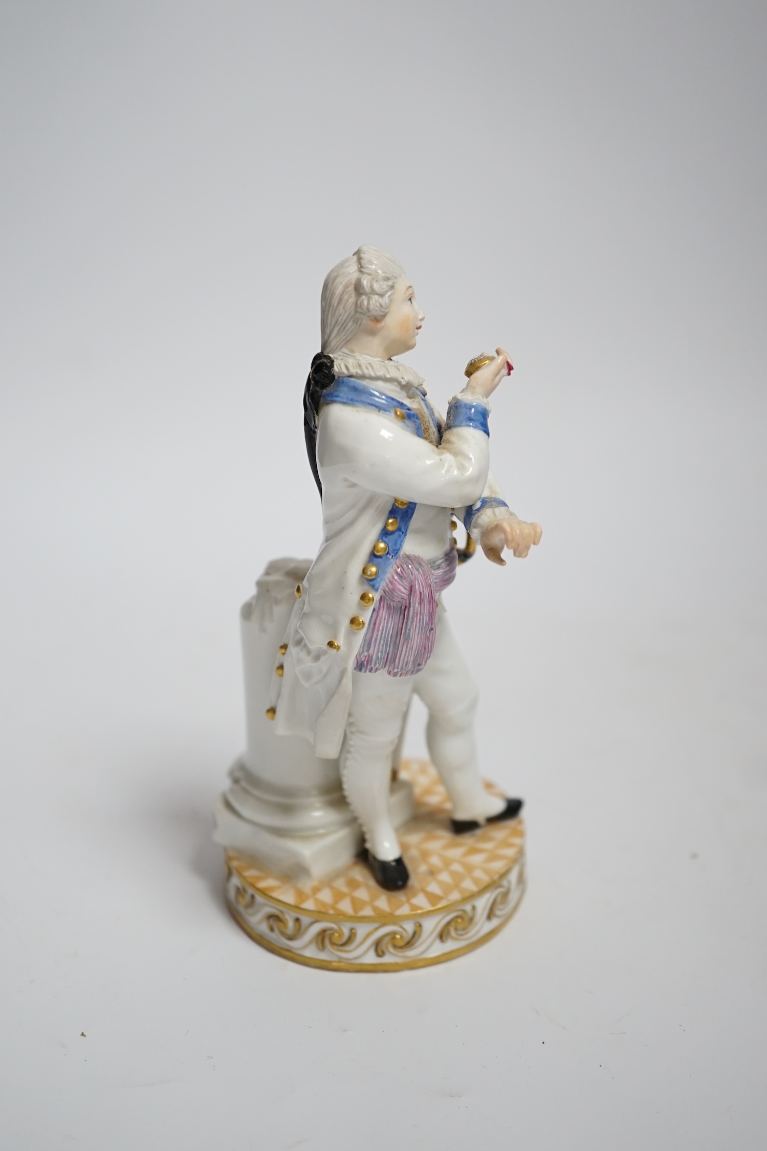 A Meissen style porcelain figure of a soldier in dress uniform with sword and holding aloft a pocket watch, on circular chequerboard decorated base with scrolled edge, height 15cm